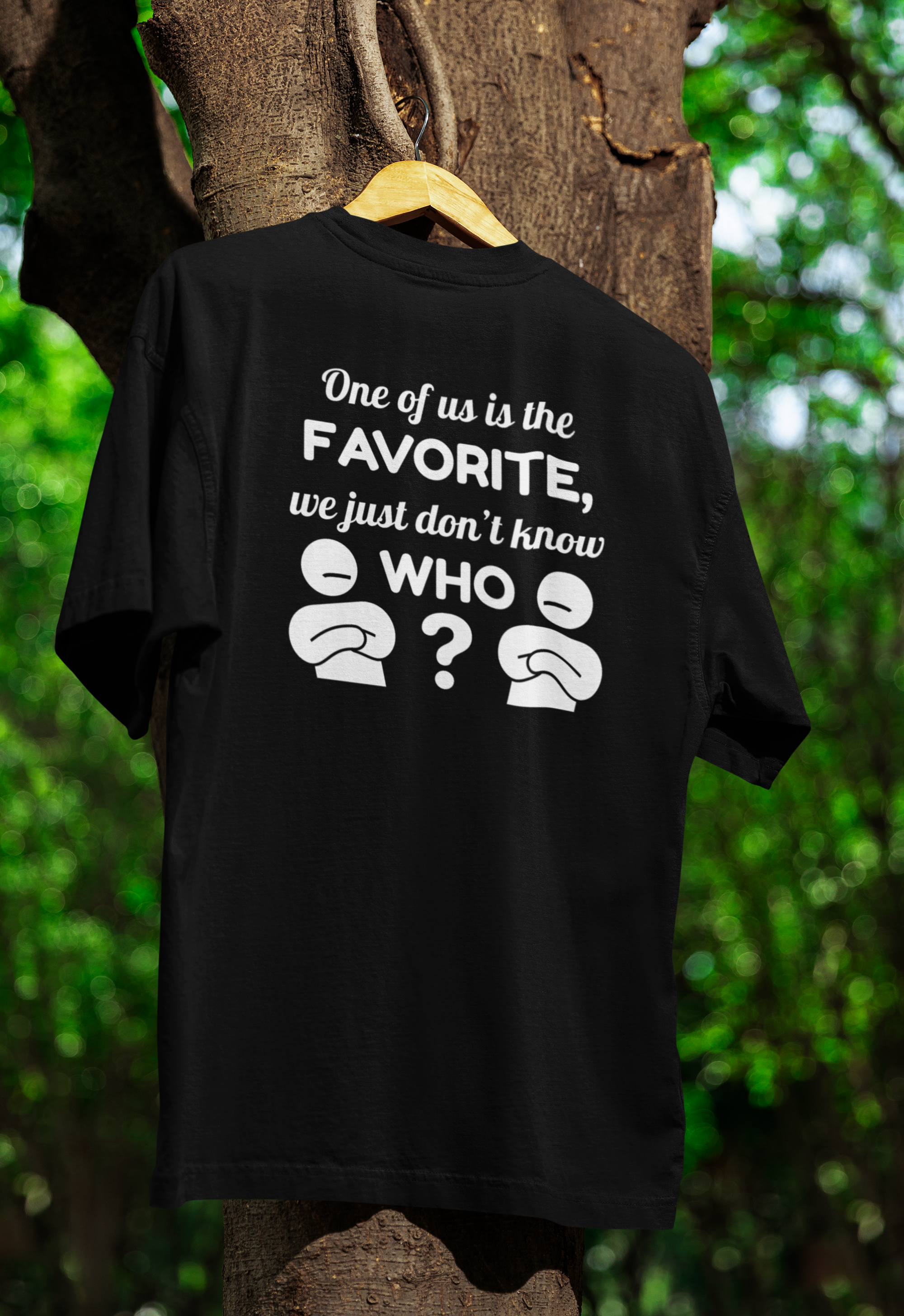 Black t-shirt for twins with humorous text and emojis on a hanger against a natural background