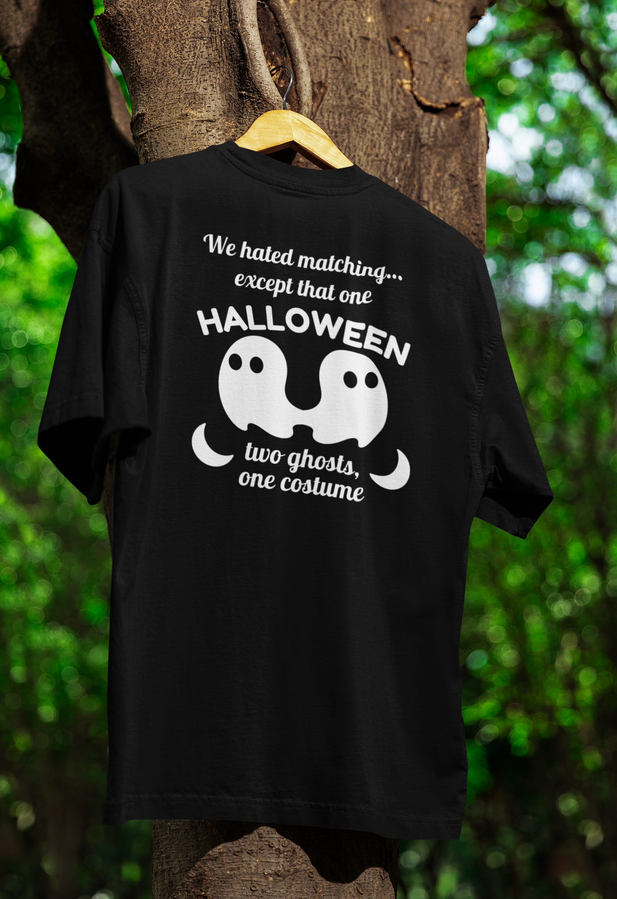 a black funny twin t-shirt hanging on a tree 
