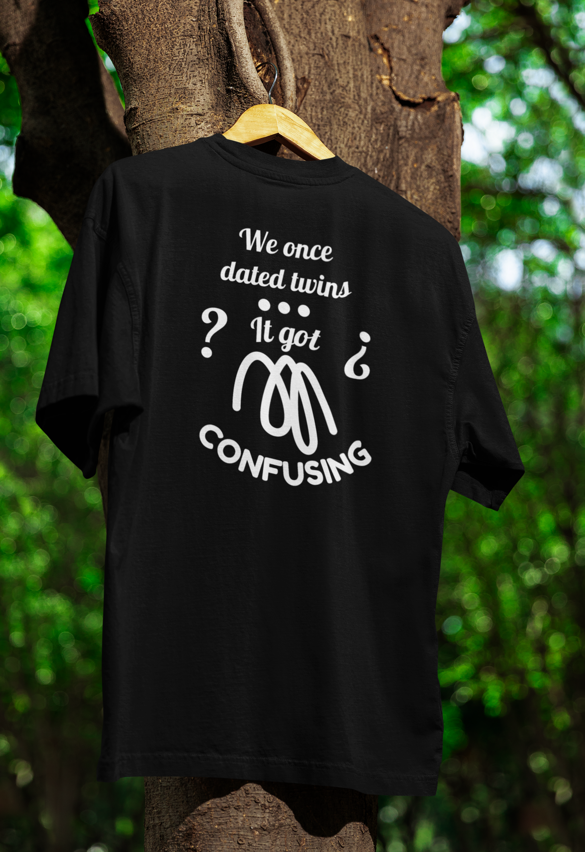 a black funny twin t-shirt hanging on a tree 