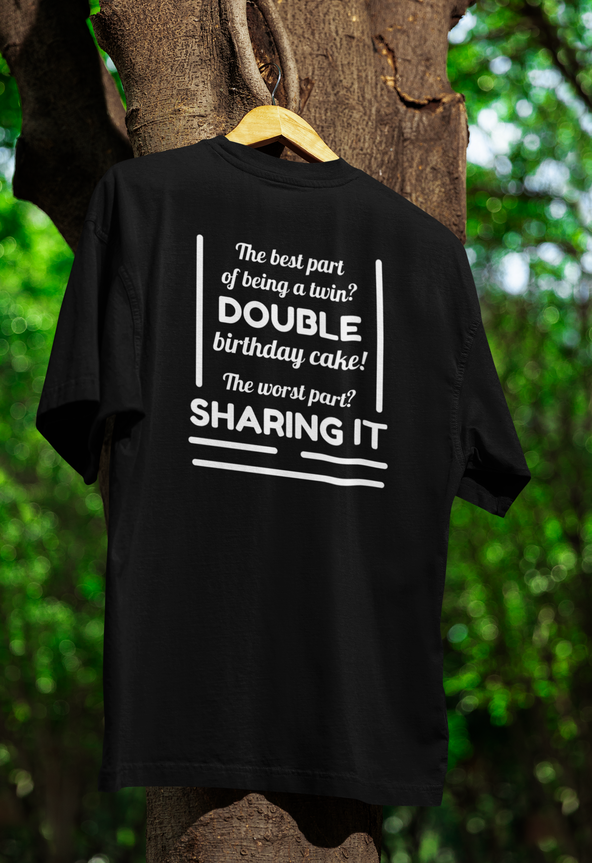 Black t-shirt for twins with humorous text design hanging on a tree