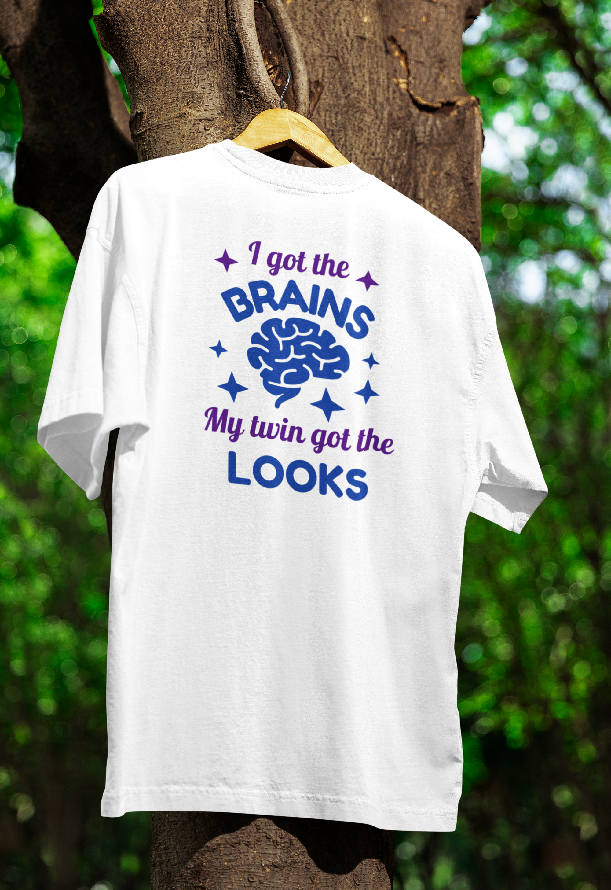 a white funny twin t-shirt for adults hanged on a tree