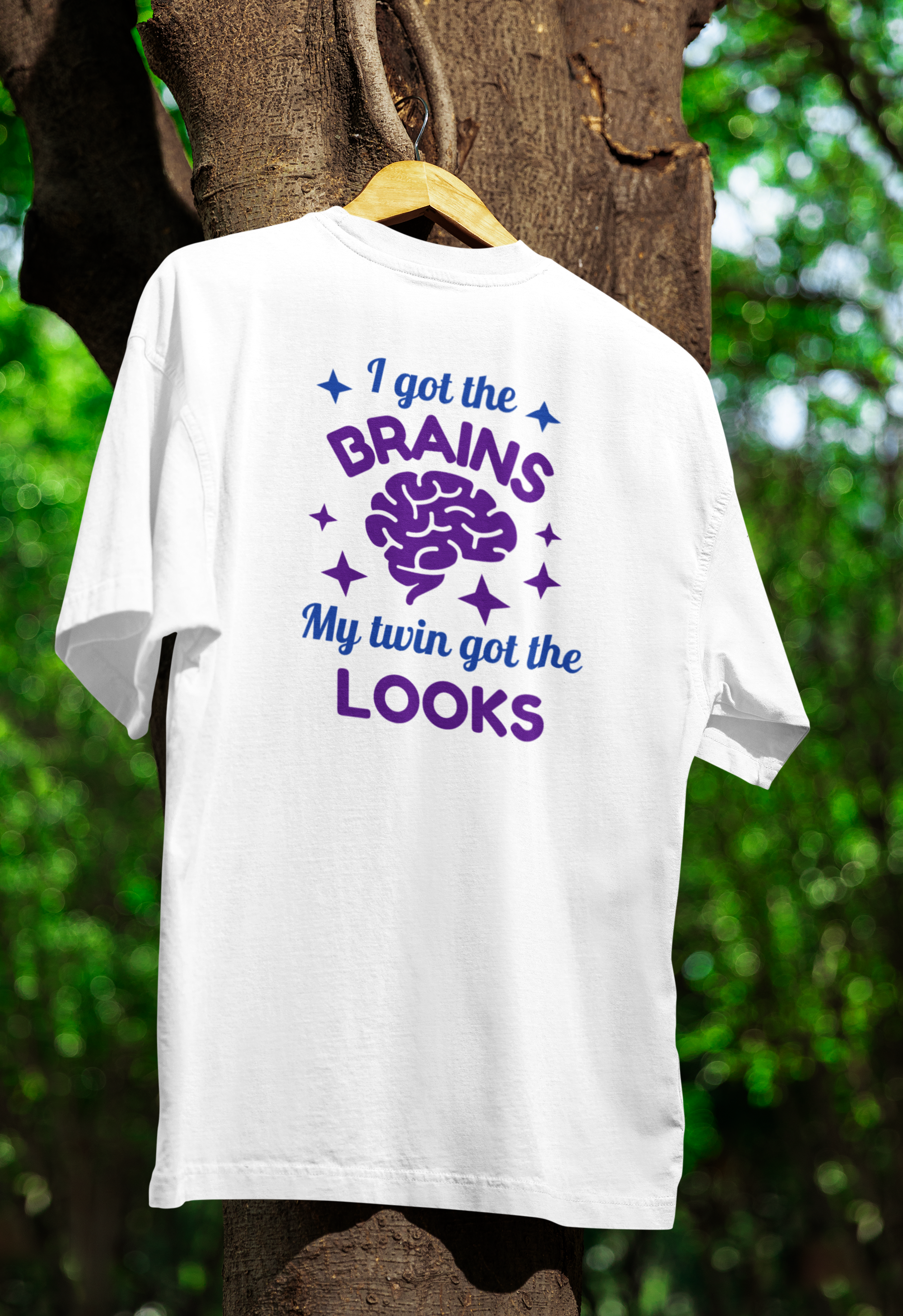 a white funny twin t-shirt hanged on a tree