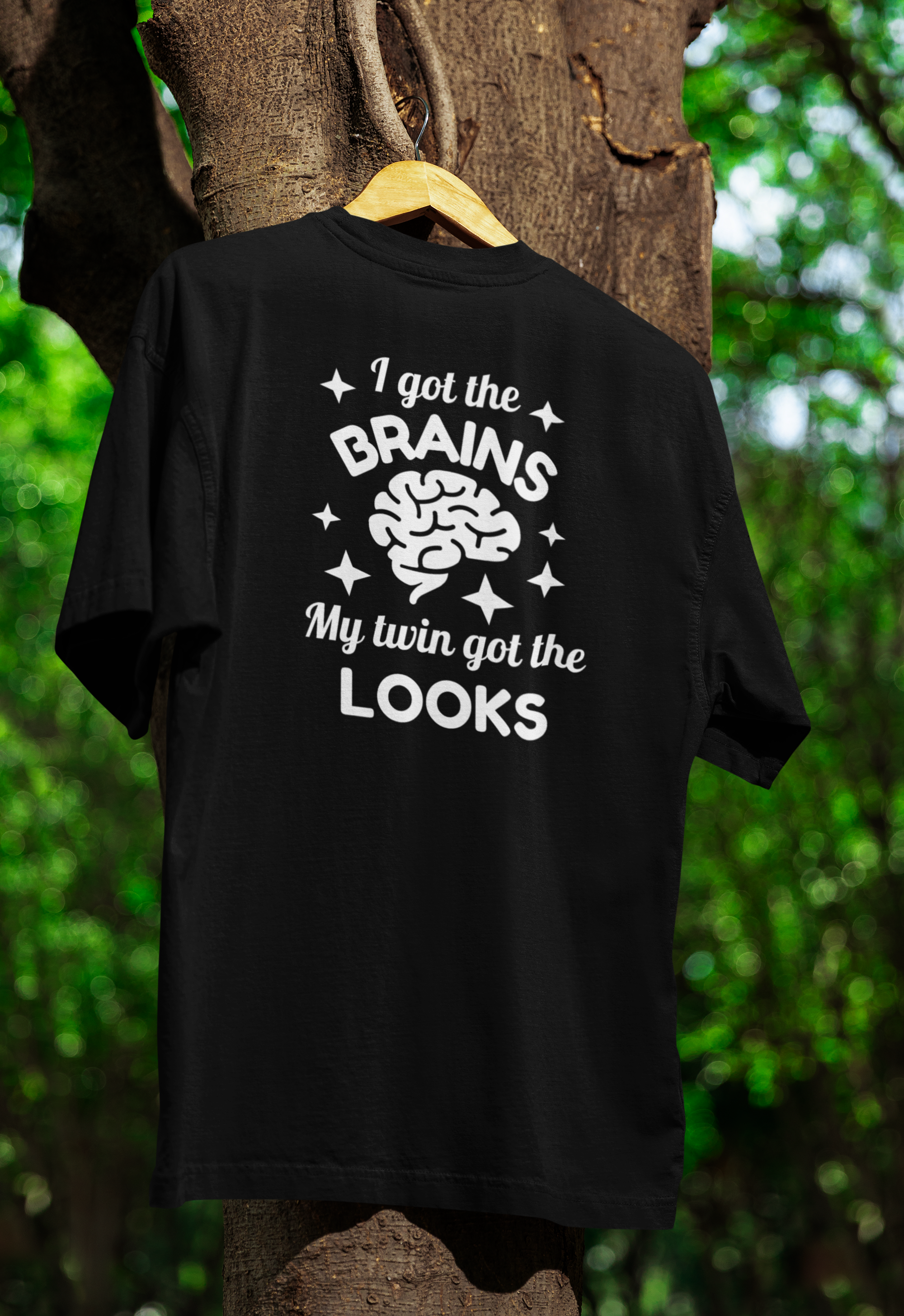 a black funny twin t-shirt hanged on a tree 