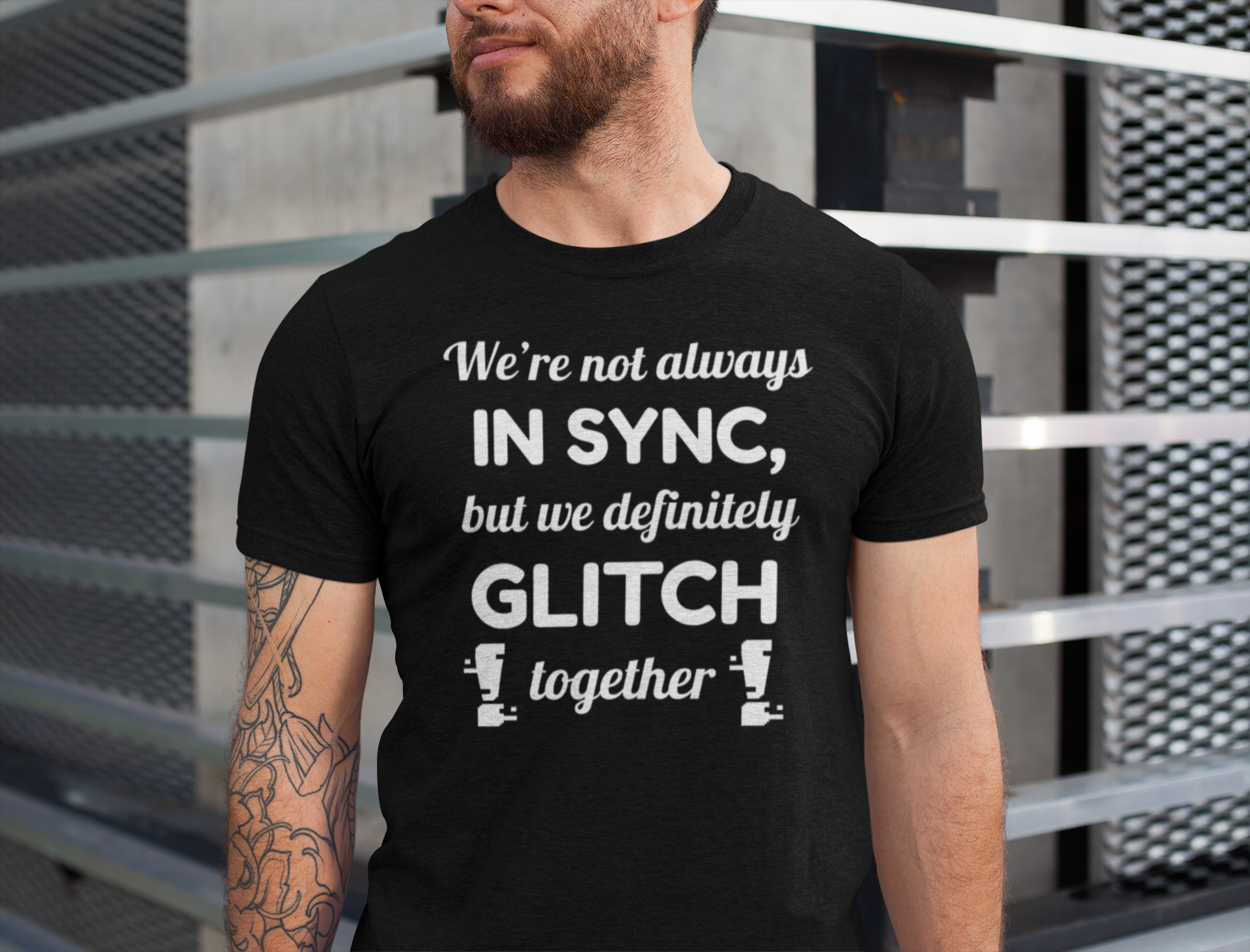 Man wearing a black t-shirt for twins with humorous text design against a metallic background