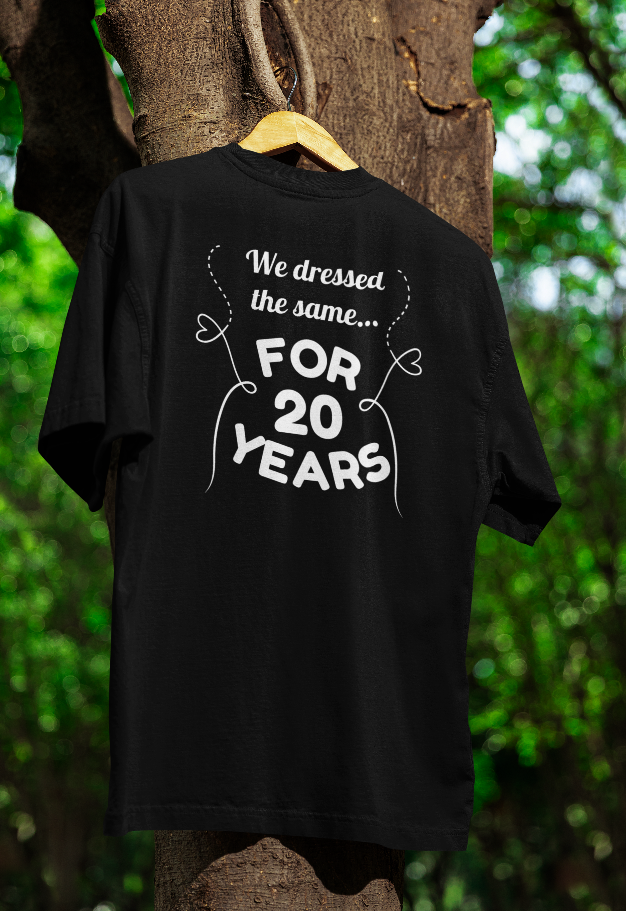 a black funny twin t-shirt hanging on a tree 