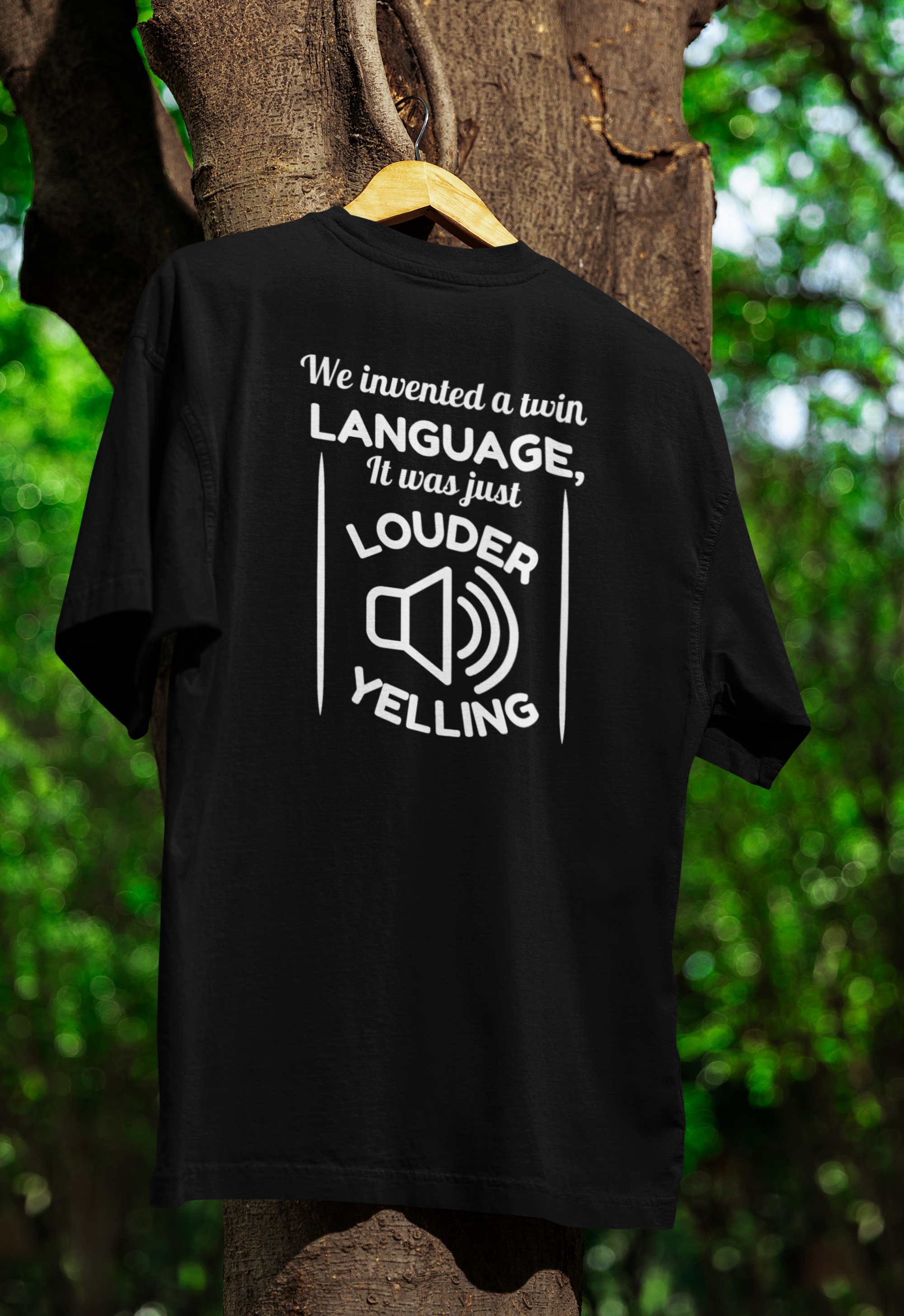 a black funny twin t-shirt hanged on a tree 