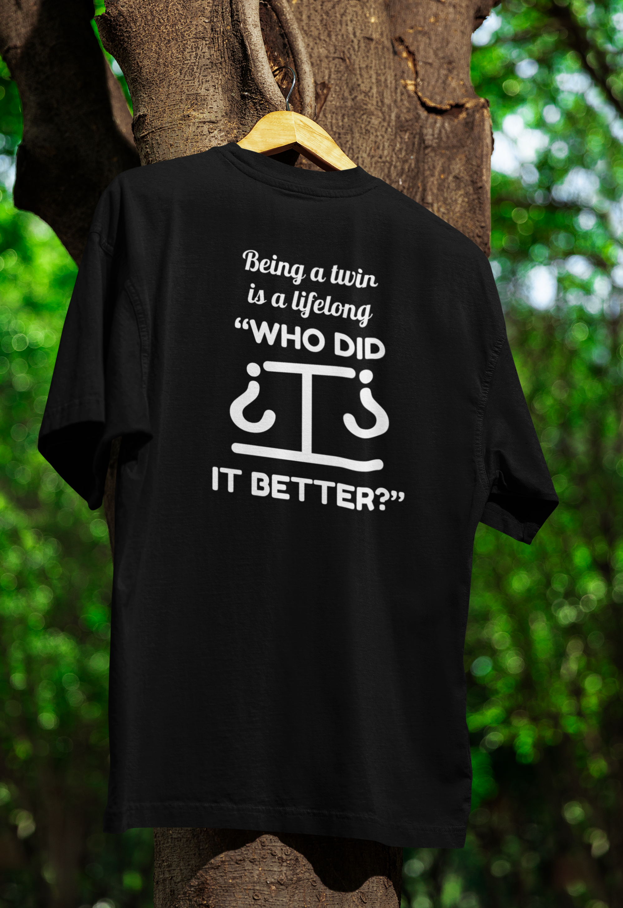 a black funny twin t-shirt hanged on a tree