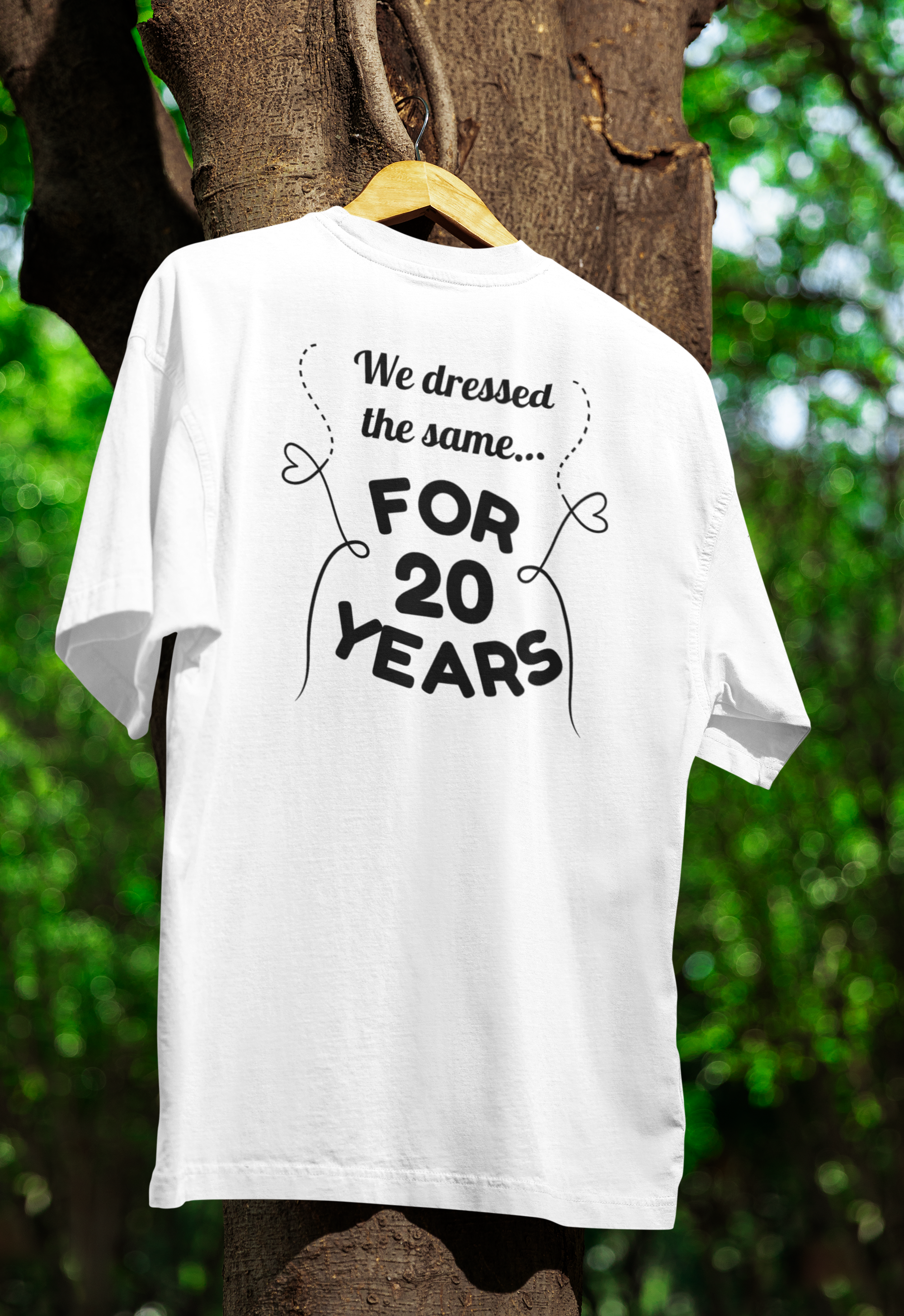 a white funny twin t-shirt hanging on a tree 