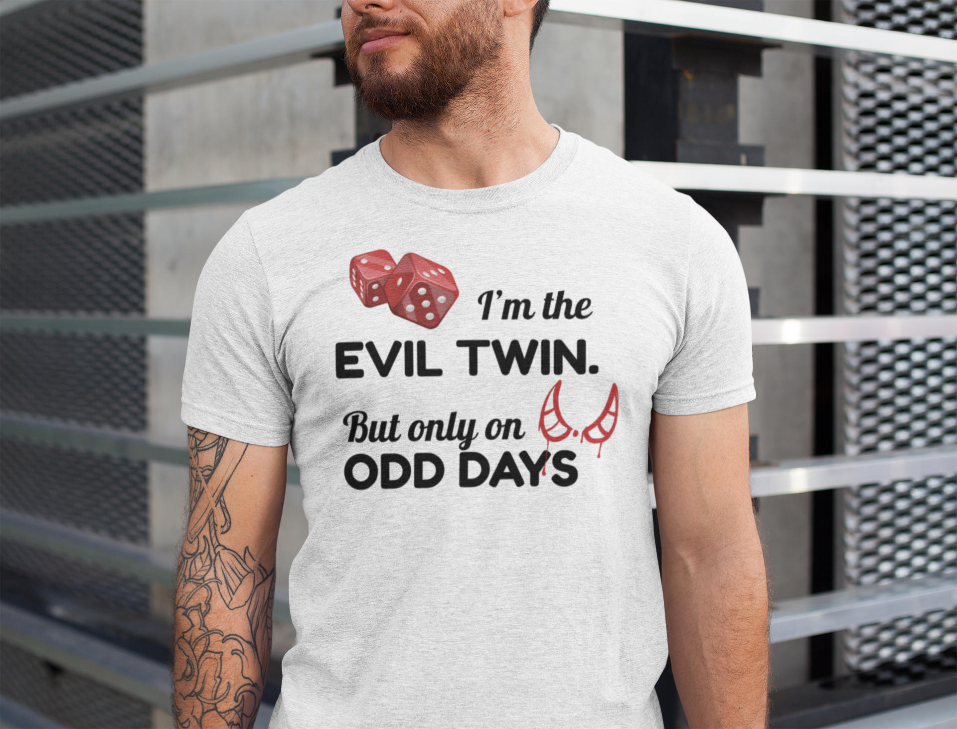 Man wearing a t-shirt for twins with a humorous text design in front of a metal fence.