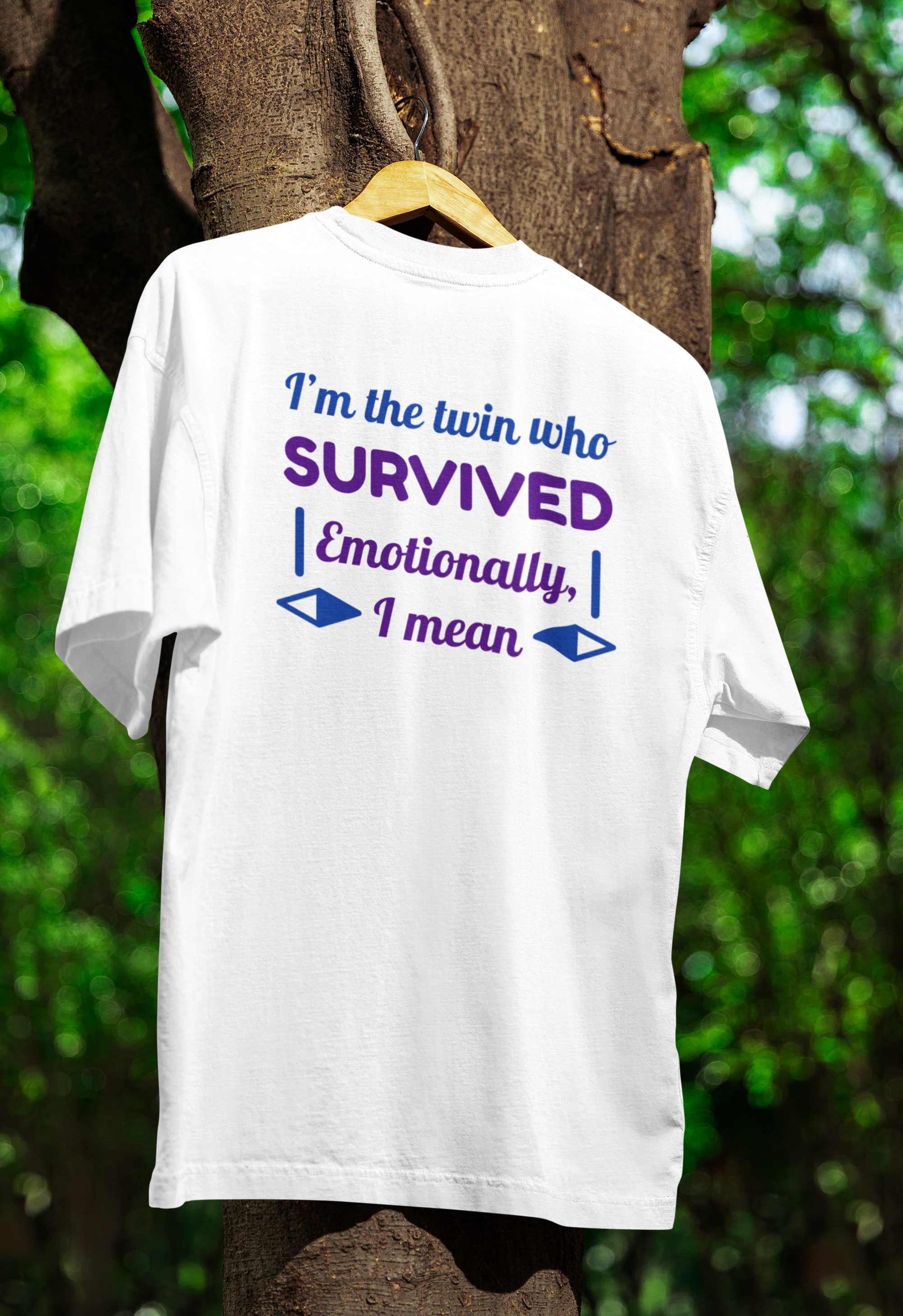 White t-shirt for twins with humorous text on a wooden hanger against a tree