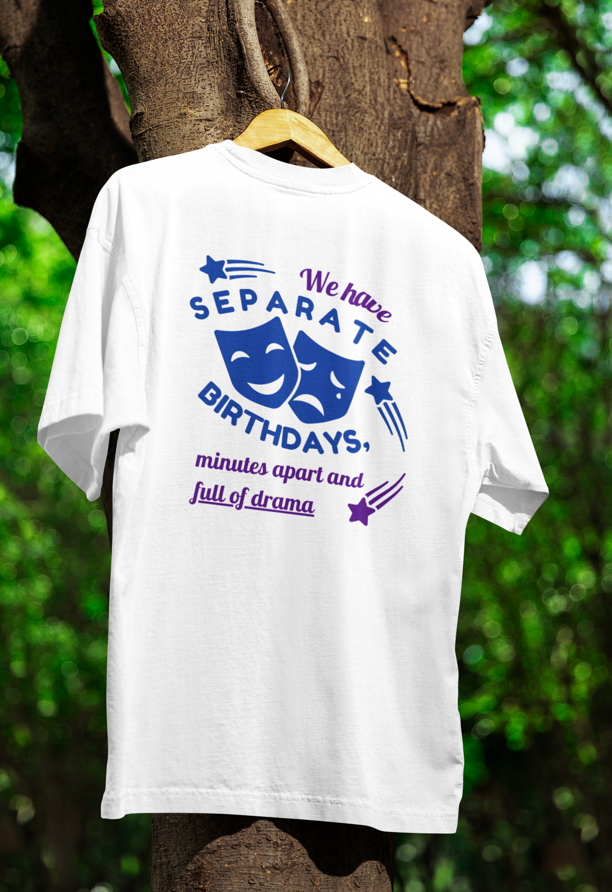 White t-shirt with humorous text design on a wooden hanger against a natural background