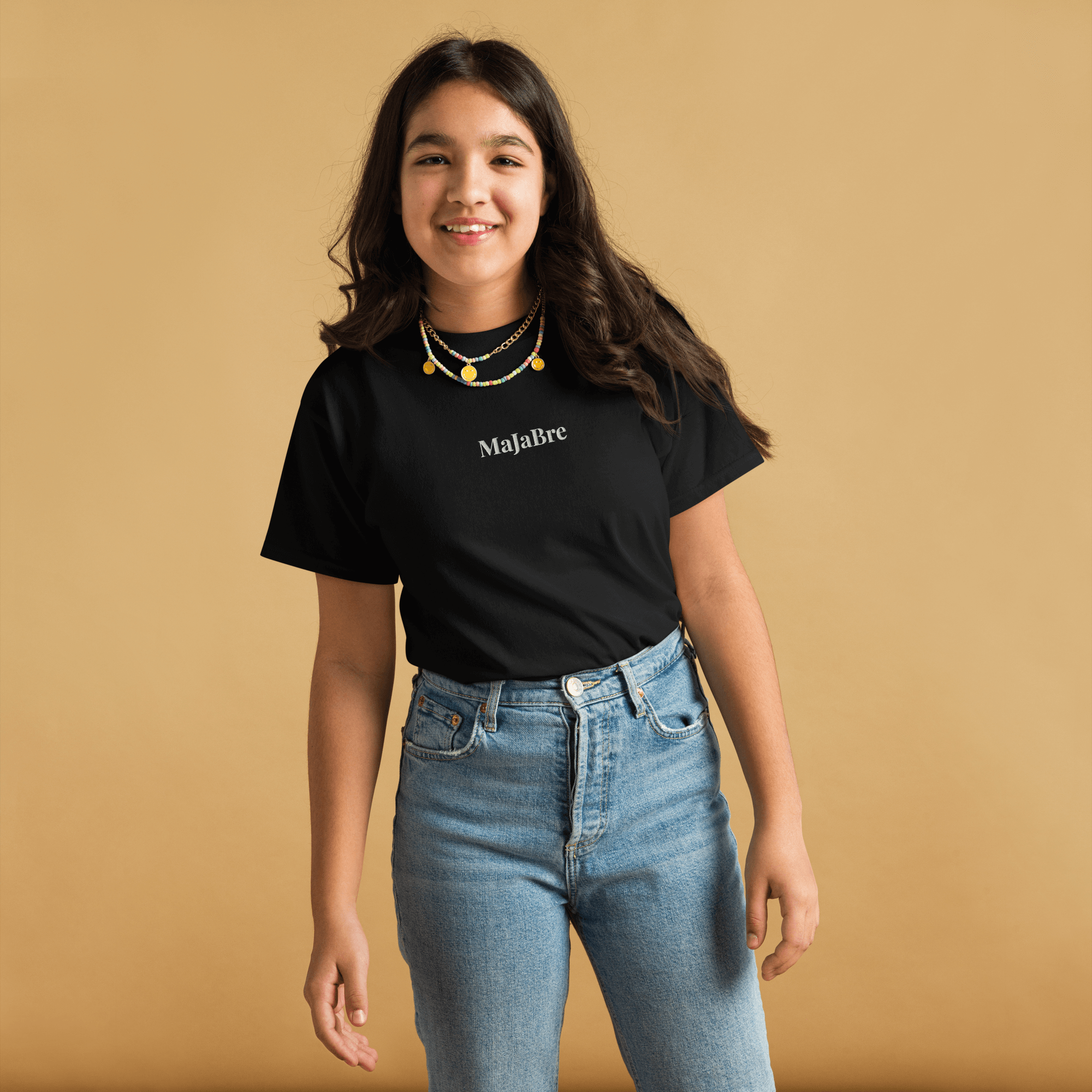 A girl wearing black twin shirt for kids with white majabre sign