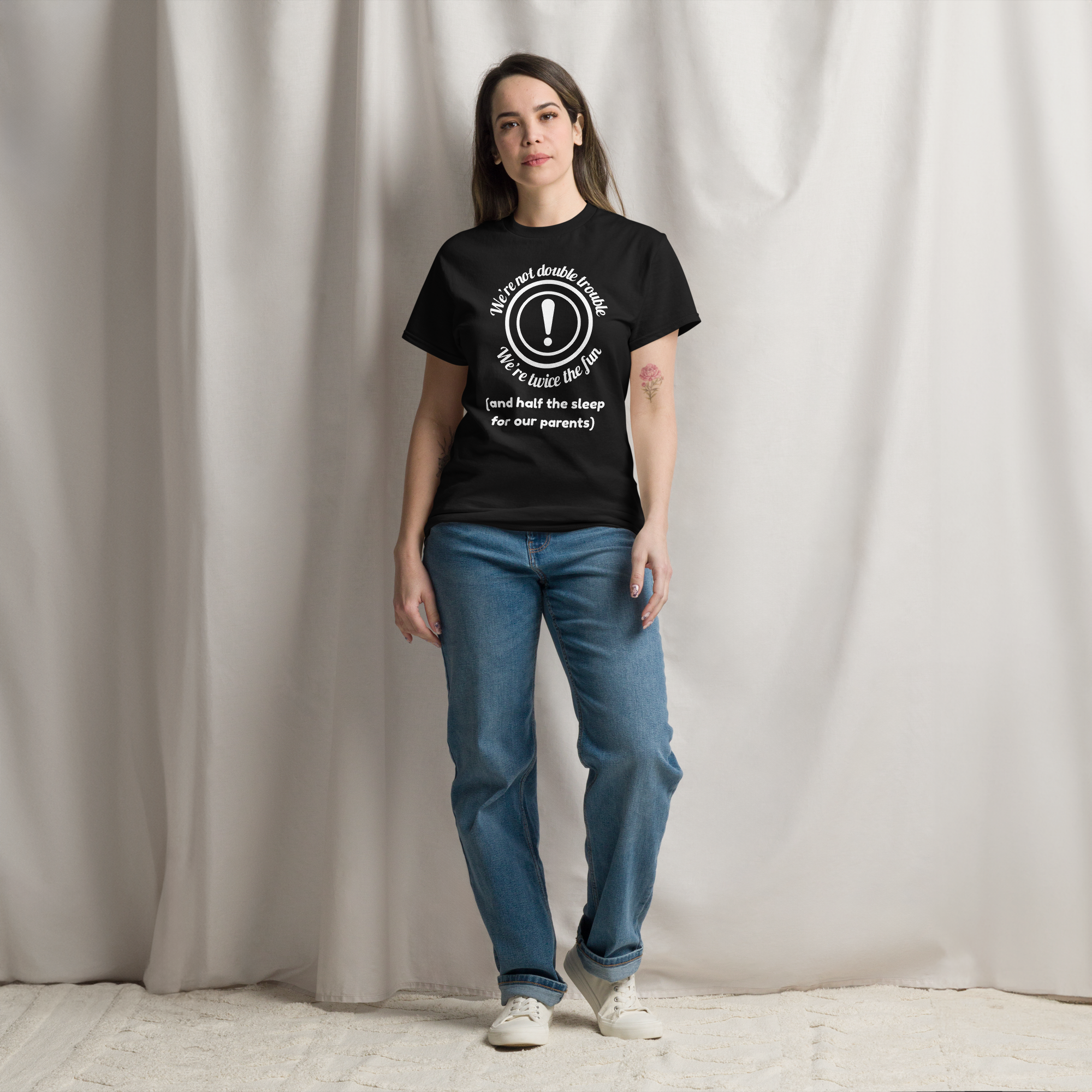 A woman wearing black twin vibes t-shirt with white text on it 